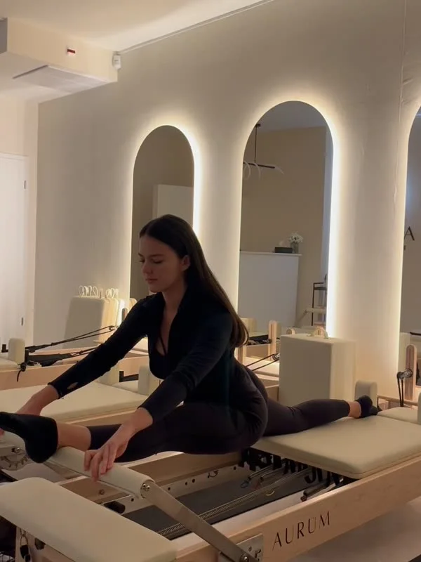 Eine Frau auf dem Reformer Gerät vor den Bogenspiegeln