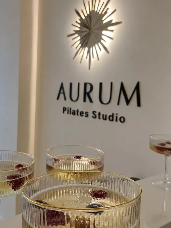 Das AURUM Logo mit Sektgläsern